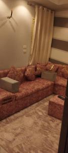a large brown couch in a room with a curtain at شقة مفروشة للايجار 4 in Mansoura
