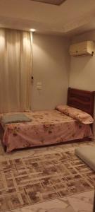 a bedroom with a bed with a pink comforter at شقة مفروشة للايجار 4 in Mansoura