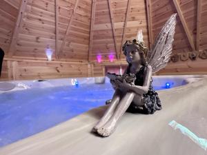 uma estátua de um anjo sentado à beira de uma piscina em Gîte Saint-Léon, 6 pièces, 12 personnes - FR-1-489-467 