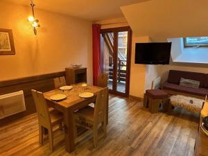 ein Wohnzimmer mit einem Tisch und einem Sofa in der Unterkunft Appartement Risoul, 1 pièce, 3 personnes - FR-1-330-574 in Risoul