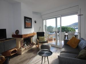 sala de estar con sofá y chimenea en Apartamento Llançà, 2 dormitorios, 4 personas - ES-228-170, en Llançà