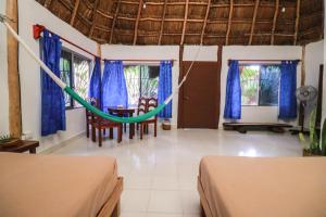 a room with two beds and a hammock in it at Playa Lakin-ha beachfront cabins in Tulum +10 photos