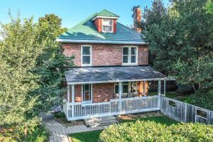 an old brick house with a large porch at Charming 3BR Century Home in Downtown Barrie in Barrie