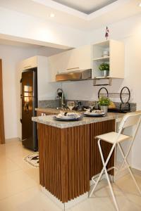 a kitchen with a counter with two chairs and a refrigerator at Casa de Nini in Santo Domingo