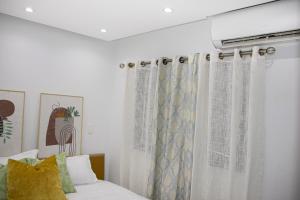 a bedroom with a bed and a window with curtains at Casa de Nini in Santo Domingo