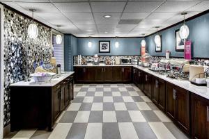 a large kitchen with wooden cabinets and a checkered floor at Wingate by Wyndham Baltimore BWI Airport in Baltimore