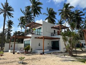 una casa en la playa con palmeras en Chansi Beachresort, en Tha Sala