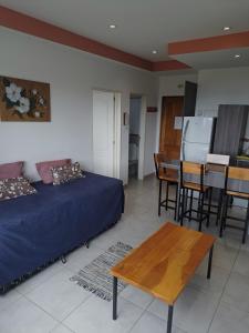 Habitación con cama, mesa y cocina. en Alem 3C en Ushuaia