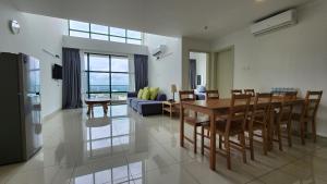 The Suites SGR Melaka في ميلاكا: غرفة طعام وغرفة معيشة مع طاولة وكراسي