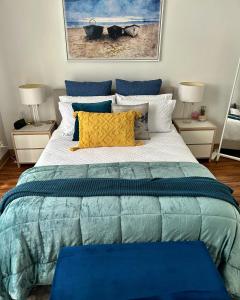 een slaapkamer met een groot bed met blauwe en gele kussens bij Sunshine Three in Salisbury