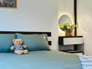 a teddy bear sitting on top of a bed at Armin Homes Căn hộ 2 Phòng ngủ Vinhomes OCP in Gia Lâm Pho