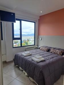 1 dormitorio con 1 cama grande y ventana grande en Alem 3C en Ushuaia