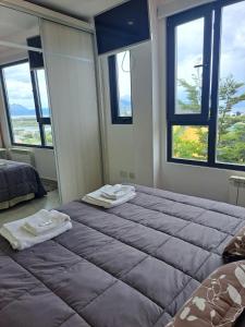 1 dormitorio con 2 camas y toallas. en Alem 3C en Ushuaia