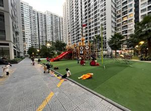 a group of people playing on a playground in a city at Armin Homes Căn hộ 2 Phòng ngủ Vinhomes OCP in Gia Lâm Pho