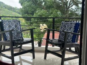 two chairs sitting on a porch with a view at YAMASÁ SHARED VILLa in Colorado