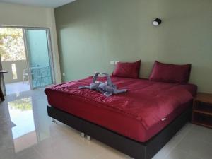 a bedroom with a large bed with a red comforter at Spy home in Khao Lak