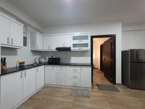 a kitchen with white cabinets and a refrigerator at Green Lake View Condo Two Bed Room Apartment in Nuwara Eliya