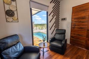 a living room with two chairs and a table and a pool at K NAJ Community in El Quelele +40 photos