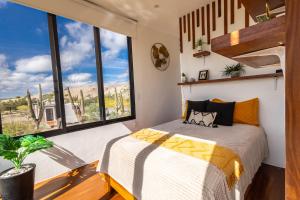 a bedroom with a bed and large windows at K NAJ Community in El Quelele