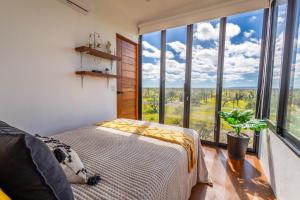 a bedroom with a bed and a large window at K NAJ Community in El Quelele