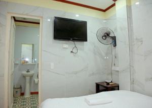 a bedroom with a tv on the wall and a bed at TUAN Central Hotel in Hanoi