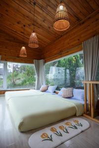 - un grand lit dans une chambre avec deux lampes suspendues dans l'établissement Đom Đóm House Đà Lạt, à Đà Lạt
