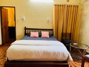 a bedroom with a bed with two pink pillows at Lavender residency in Varkala