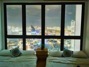 Zimmer mit 2 Betten und einem großen Fenster in der Unterkunft Nordic Apartment, KLCC ZenSuites in Kuala Lumpur