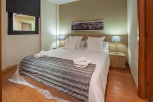 Habitat Apartments Carders في برشلونة: غرفة نوم بسرير كبير عليها مناشف