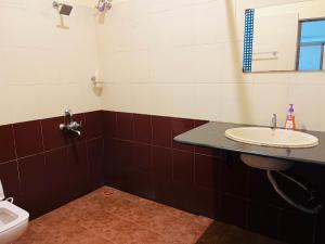 a bathroom with a sink and a toilet at Lavender residency in Varkala