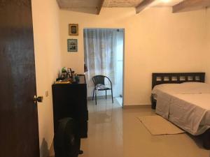 1 dormitorio con 1 cama, 1 mesa y 1 silla en Casa en playa los Chimus / Samanco / Ancash, en Tortuga