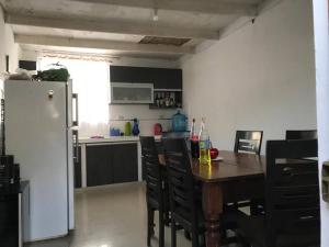 Il comprend une cuisine équipée d'une table, de chaises et d'un réfrigérateur. dans l'établissement Casa en playa los Chimus / Samanco / Ancash, à Tortuga
