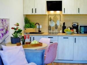 a kitchen with a table with pink and blue chairs at Terraced house for 4 people, Mielenko in Mielenko