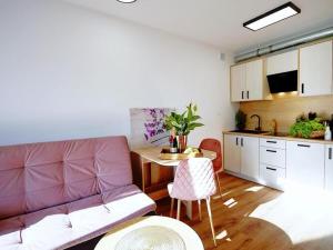 uma sala de estar com um sofá, uma mesa e uma cozinha em Comfortable terraced house, Mielenko em Mielenko