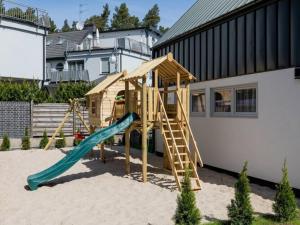 a wooden playground with a slide in the sand at Holiday cottages close to the beach, Pobierowo in Pobierowo