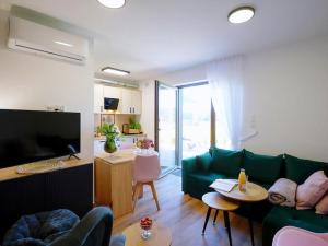 un salon avec un canapé vert et une table dans l'établissement Comfortable holiday homes with terraces, Mielenko, à Mielenko