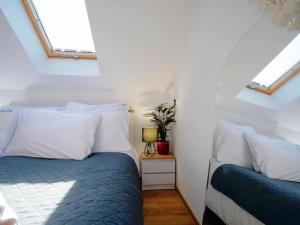 a bedroom with a bed with white pillows and a window at Comfortable holiday home, Mielenko in Mielenko
