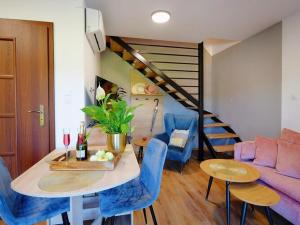 a living room with a table and blue chairs and a staircase at Terraced holiday house, 2 bedrooms, Mielenko in Mielenko