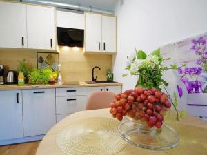 a bowl of grapes on a table in a kitchen at Terraced house for 4 people Mielenko in Mielenko