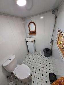 baño pequeño con aseo y suelo de baldosa. en Palanta Roemah Kajoe Syariah Villa, en Kampungdurian