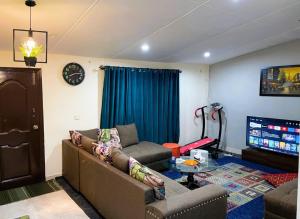 ein Wohnzimmer mit einem Sofa und einem TV in der Unterkunft QB Elegant Villa with Valley View in Rawalpindi