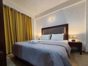 una camera con un grande letto e tende gialle di Green Lake View Condo Two Bed Room Apartment a Nuwara Eliya