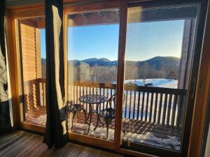 a screened in porch with a table and a view of the mountains at White Mountains Getaway with amazing views! in Bartlett