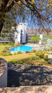 a swimming pool in a yard with a building at Departamento frente a lago Carlos Paz - Villa Siquiman - Complejo Veneto Village in Villa Parque Siquiman