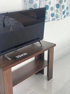 uma televisão numa mesa de madeira com controlo remoto em ภูม่านหมอก เขาค้อ em Ban Khao Ya Nua