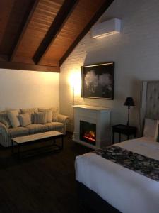 a hotel room with a fireplace and a bed and a couch at Olde Horsham Motor Inn in Horsham