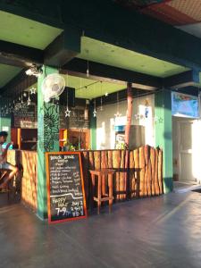 un restaurante con una mesa y un cartel delante en Beach Break Surf Hostel, en Weligama
