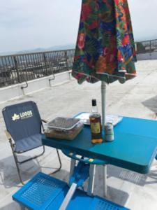 einen blauen Tisch mit einem Regenschirm und einem Stuhl in der Unterkunft Big Stone Tsukuda 45平米 2SDbed 2For3F in Aomori