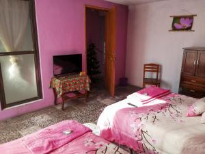 1 dormitorio con 2 camas, mesa y espejo en La Carreta Rica, en Zitácuaro
