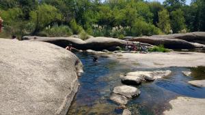 un grupo de personas nadando en un río con rocas en Cabaña Siquiman in 